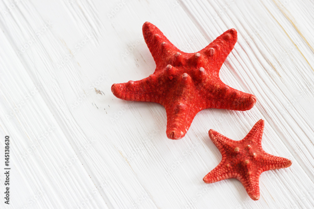 A couple of starfishes on white wooden table. Background. A couple of starfishes on white wooden table. Background.