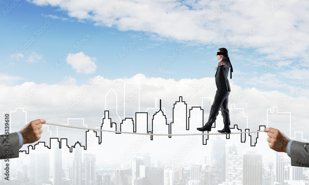 Business concept of risk support and assistance with man balancing on rope Business concept of risk support and assistance with man balancing on rope