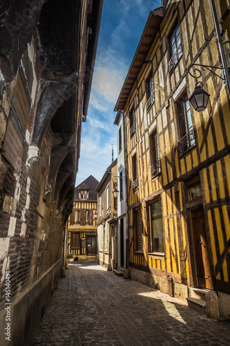 A characteristic narrow street in the French medieval town of Troyes with traditional Tudor architecture. No people