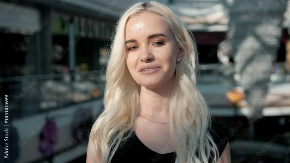 Portrait of beautiful happy blonde woman in shopping mall, student girl Portrait of beautiful happy blonde woman in shopping mall, student girl