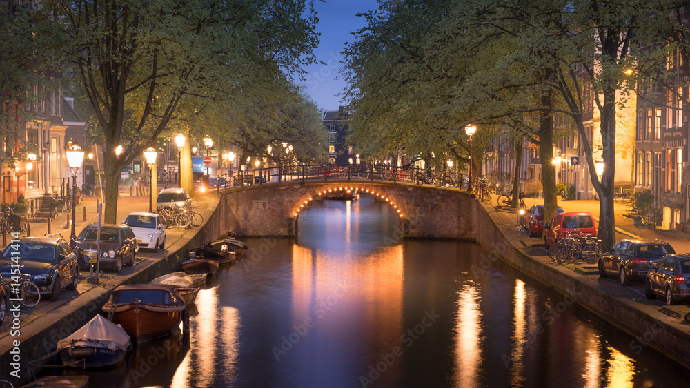 Beleuchtete Brücke mit Spiegelung in Amsterdam