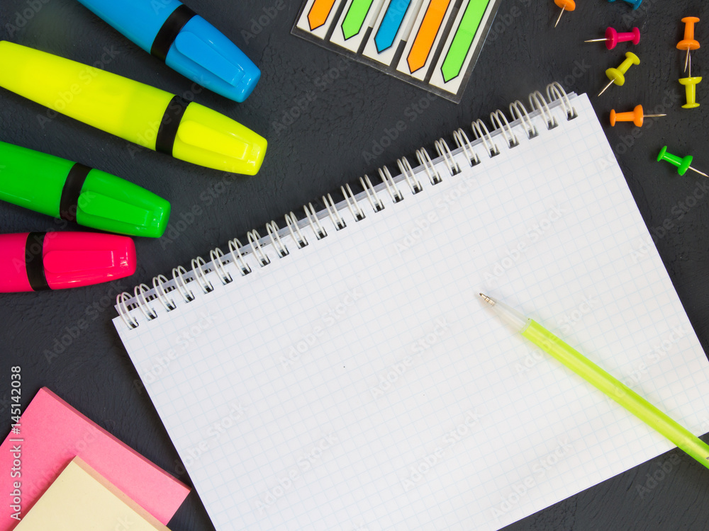 Notepad, pens, pencils, stationery for school and business on black background Flat lay Notepad, pens, pencils, stationery for school and business on black background Flat lay