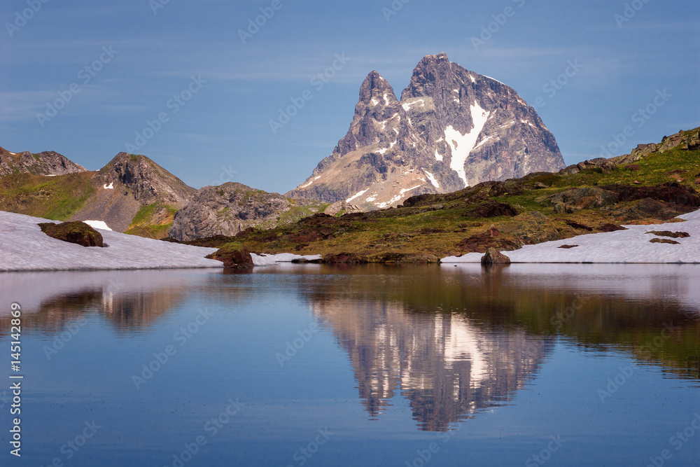 The Midi d'Ossau peak reflected in a lake in the Pyrenees National Park, Spain