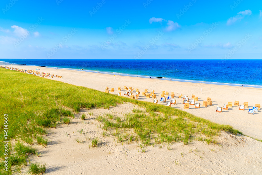 Grass on sand dune and wicker chairs on Wenningstedt beach, Sylt island, Germany