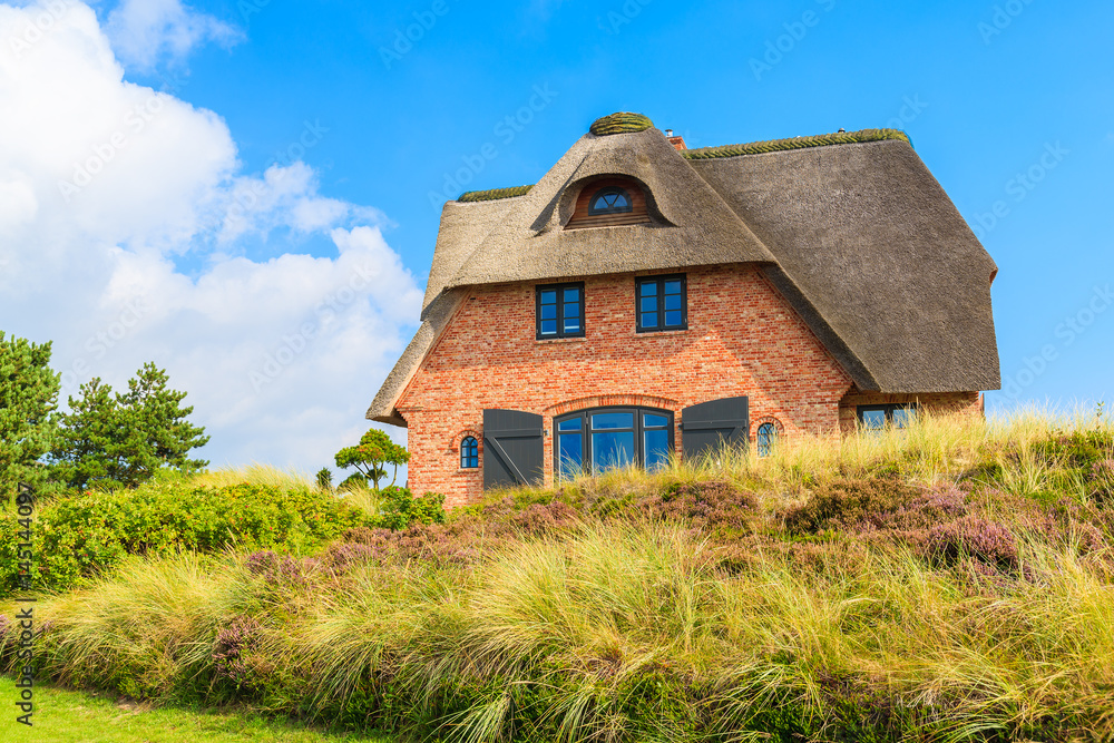 Typical Frisian house with thatched roof on Sylt island in Westerheide village, Germany Typical Frisian house with thatched roof on Sylt island in Westerheide village, Germany
