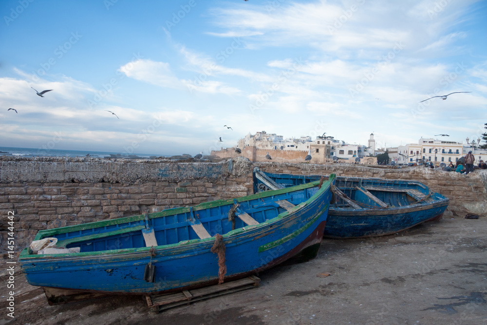 MOROCCO, ESSAOUIRA - January 09, 2013. Fishing blue boats in port of Essaouira harbour with fishmens.