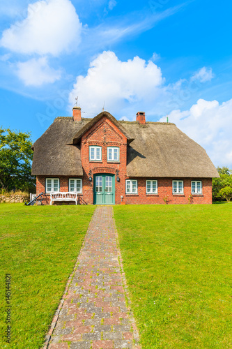 Typical red brick Frisian house with thatched roof on Sylt island in List village, Germany