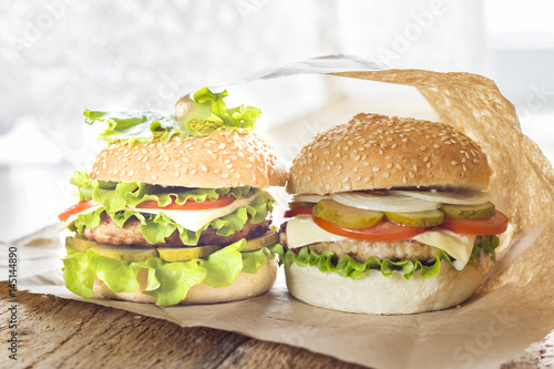 Homemade hamburger with fresh vegetables on a wooden background