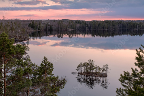 Landscape nature image of sunset over forest lake in Tyresta National Park in Stockholm, Sweden.