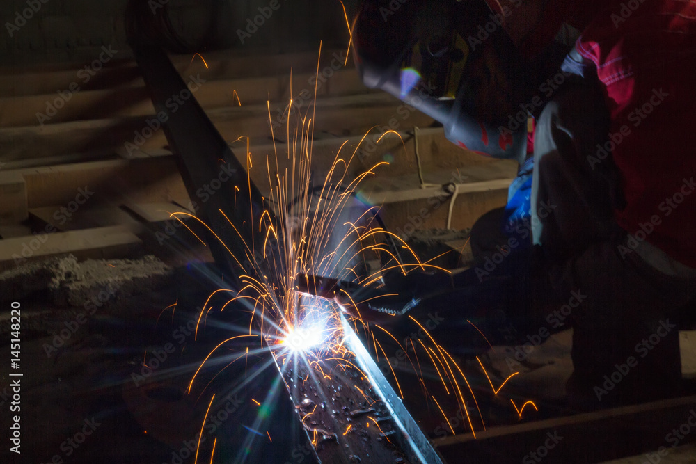 Welder in a protective suit and mask at work Welder in a protective suit and mask at work