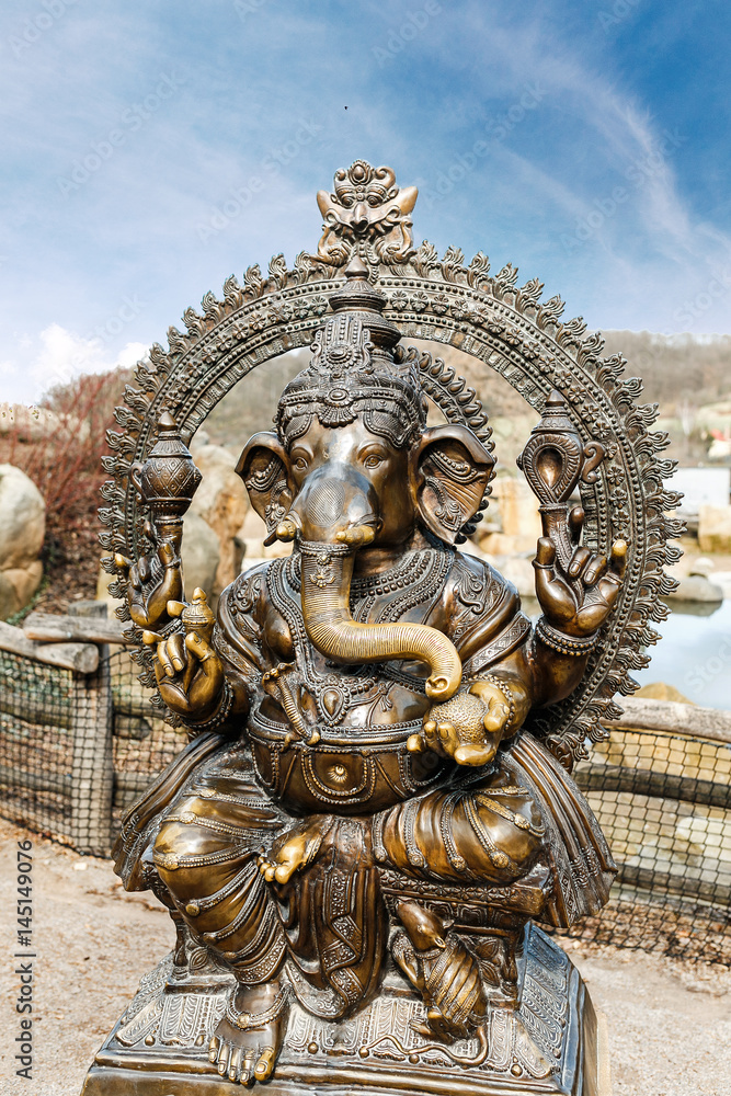 Statue of Hindu Elephant God Ganesha outdoors against dramatic sky
