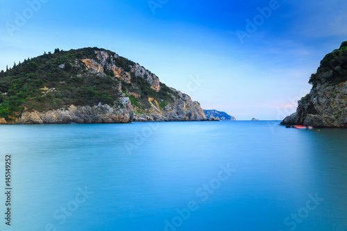 Long exposure landscape of Paleokastritsa famous sand beach in close bay on Corfu island at dusk, Ionian archipelago, Greece.