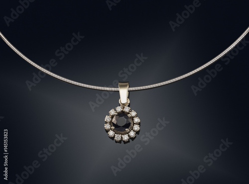 Golden necklace with gemstone isolated on black