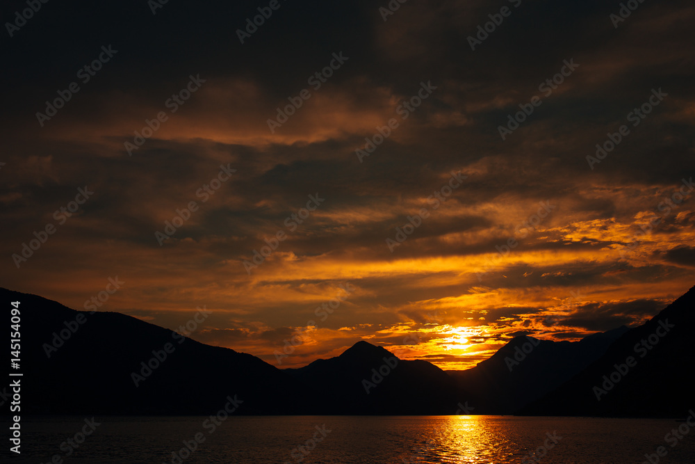 Sunset in Montenegro over the mountains and the sea. Orange sunsets.