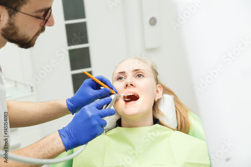 Fototapeta Naklejka Na Ścianę i Meble -  Dentist performs the procedure of dentistry