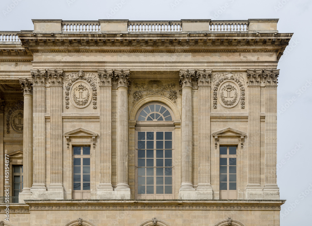 Corner part of the Louvre Museum facade with details of the windows and embedded columns on this beautiful baroque architectural landmark