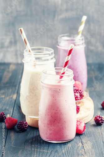 Berry smoothies with yoghurt, gray background, selective focus