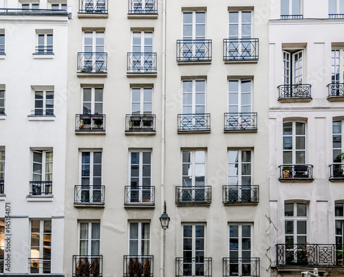 Historic facades with french balconies or balconettes on old classic parisian buildings