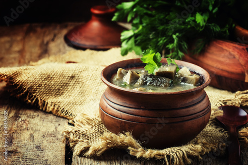 Mushroom soup in a clay pot, rustic style, selective focus