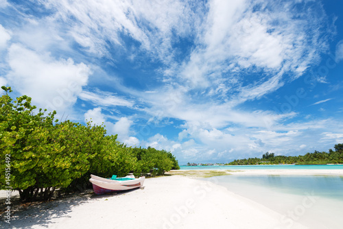 Wooden boat on the white sand beach.Maldives islands