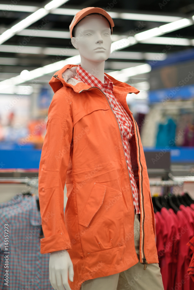 Obraz premium Mannequin with orange winter jacket on it in outdoor clothes store