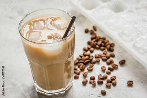 Ice coffee with milk and beans for lunch on stone background