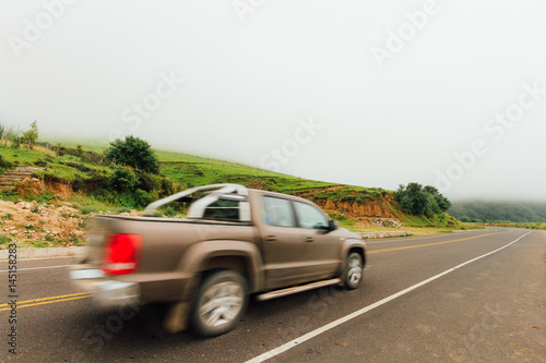 Pickup truck travels along a road with fog Tucuman, Argentina