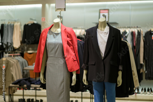 Man and woman mannequins in modern style dresses and sport jackets on in clothes store © Joshhh