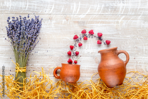 laveder composition with jar, cup, raspberry on rustic background top view mock-up photo