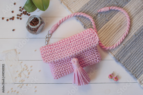 Female handbag handmade pink color on a white background with a jar of coffee and beads