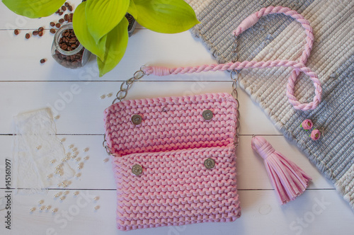 Female handbag handmade pink color on a white background with a jar of coffee and beads