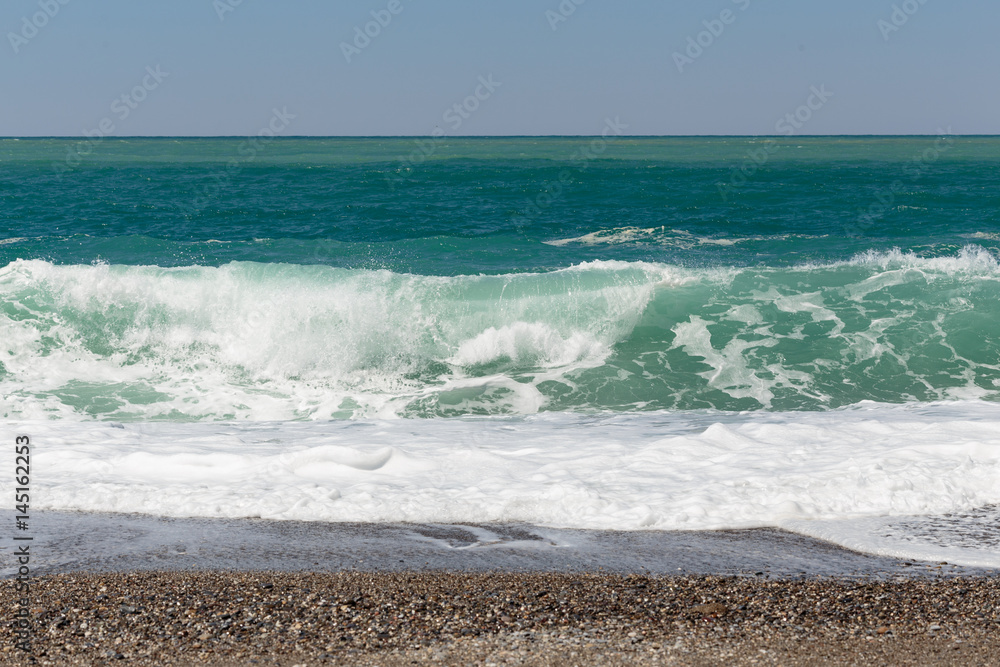 Beautiful wave washing pebble beach