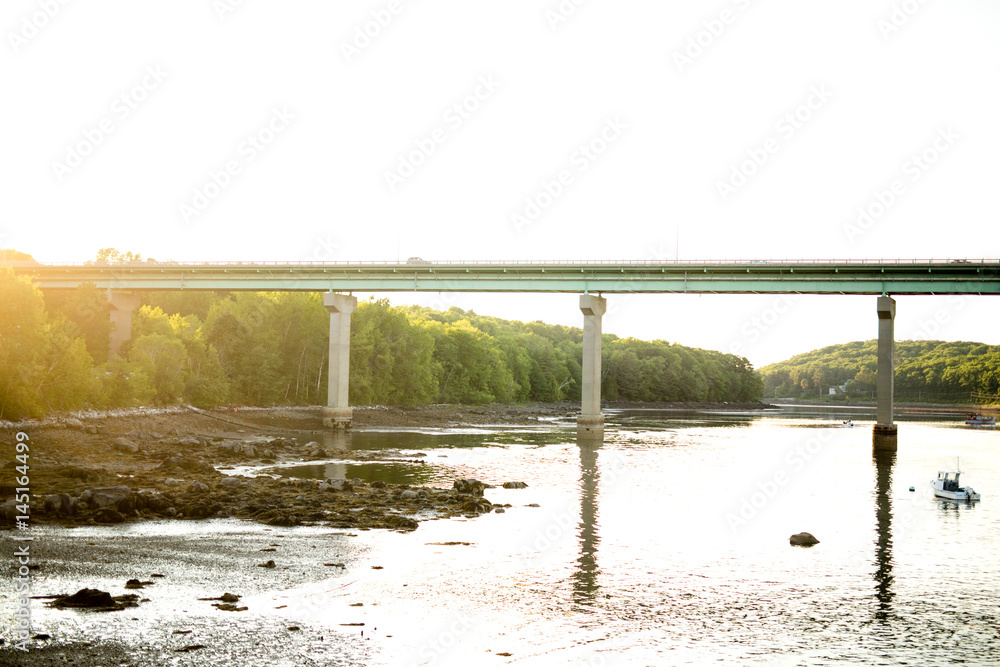 Road bridge reflected in river at sunset Road bridge reflected in river at sunset
