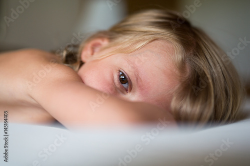 Close up child's face and bare shoulders lying down