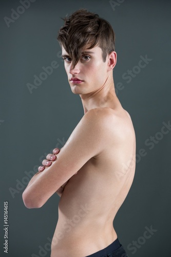 Shirtless androgynous man posing with arms crossed