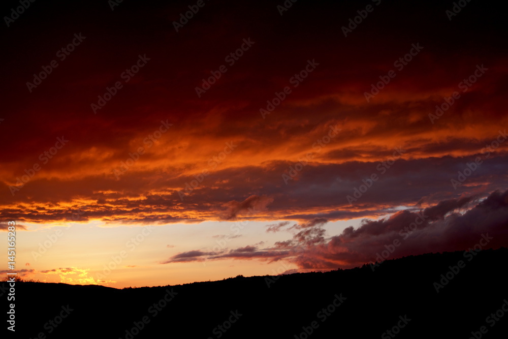 sunset landscape small mountain with clouds in the sky red