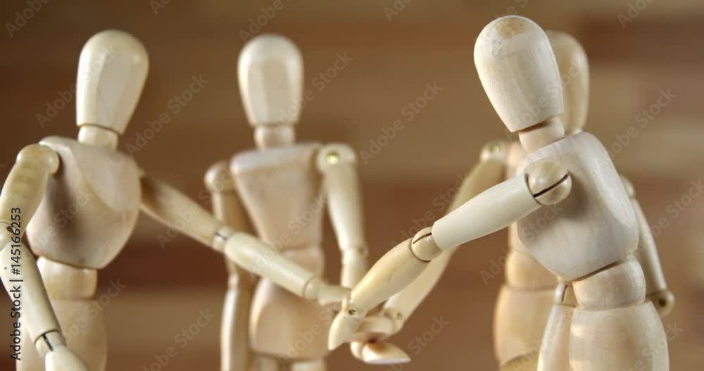 Wooden figurines representing businesspeople forming a handstack Wooden figurines representing businesspeople forming a handstack