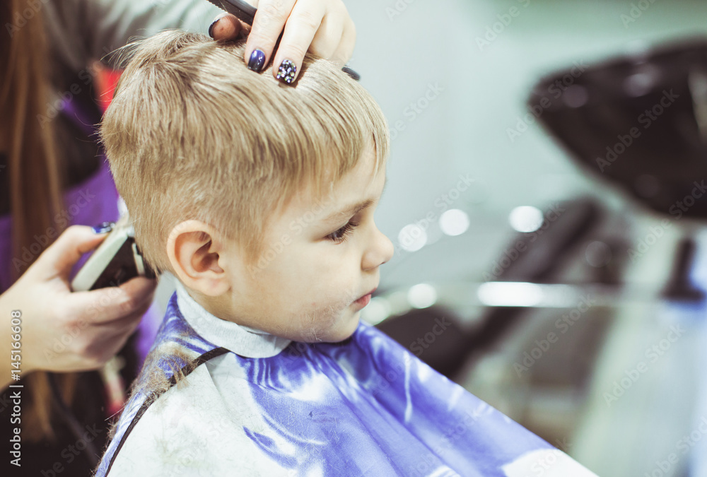Little boy makes hairstyle at the hairdresser Little boy makes hairstyle at the hairdresser