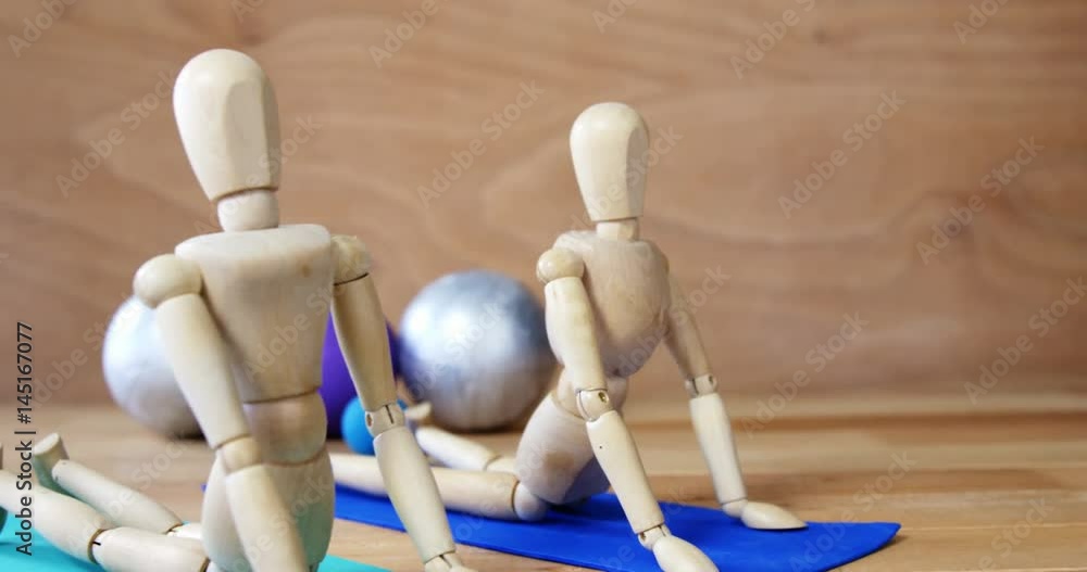 Wooden figurine exercising on exercise mat Wooden figurine exercising on exercise mat