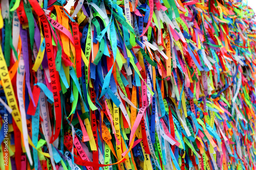 Colorful ribbons in front of a catholic church called Senhor do Bonfim in Salvador, Bahia in Brazil. Famous touristic place where people make wishes while tie the ribbons in the Carnival land. photo