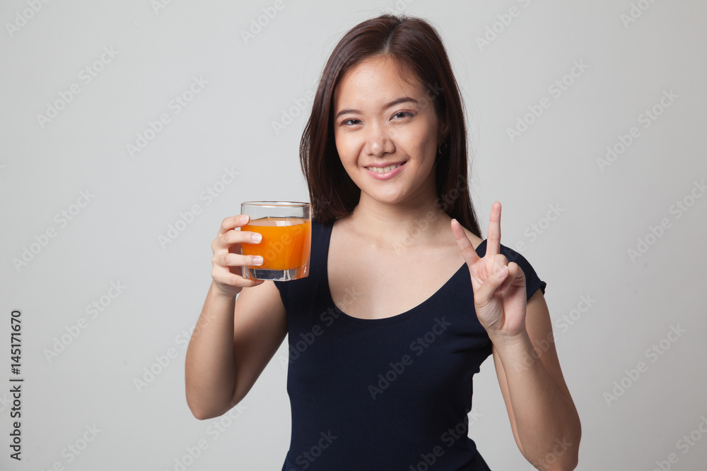 Young Asian woman show victory sign drink orange juice. Young Asian woman show victory sign drink orange juice.