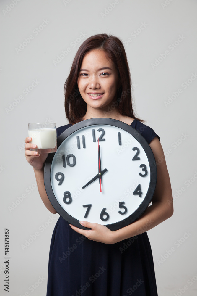 Healthy Asian woman drinking glass of milk hold clock. Healthy Asian woman drinking glass of milk hold clock.