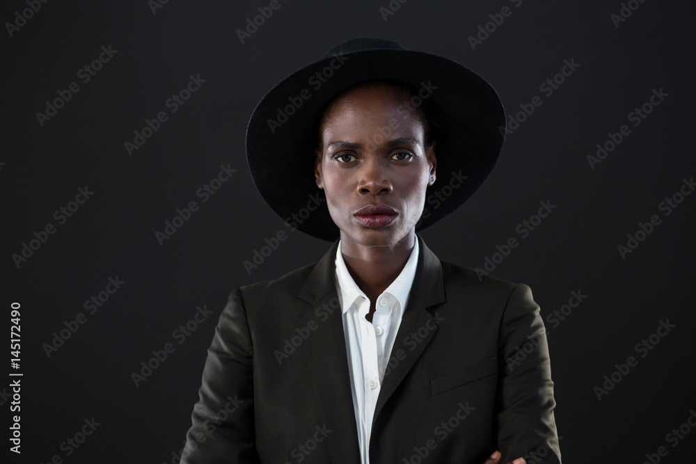 Androgynous man in suit posing against grey background Androgynous man in suit posing against grey background