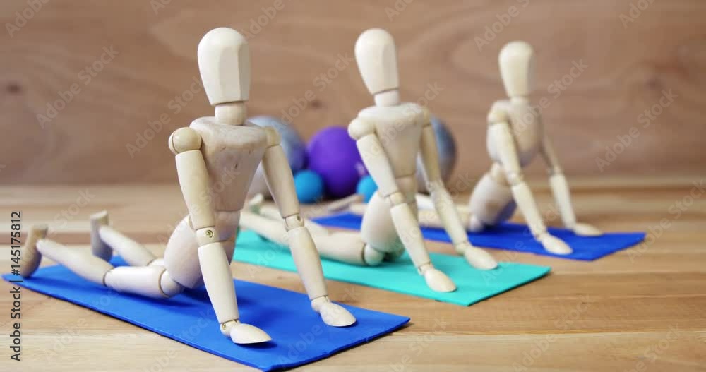Wooden figurine exercising on exercise mat Wooden figurine exercising on exercise mat