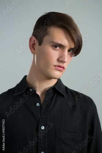 Androgynous man posing against grey background