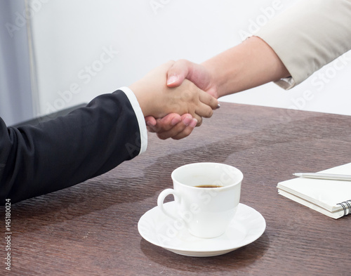 Handshake to seal a deal after a job recruitment meeting. Two business people shaking hands. Senior businessman shaking hands  in a modern office.Lighting and color effect.