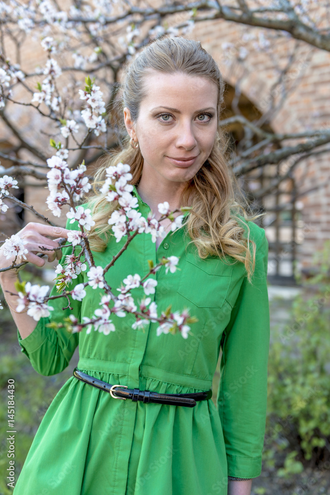 Young blonde girl on the background of a spring blooming garden
Young blonde girl on the background of a spring blooming garden