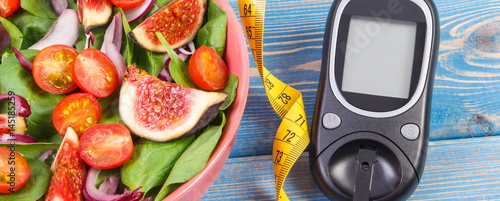Fruit and vegetable salad and glucometer with tape measure, concept of diabetes, slimming and healthy nutrition
