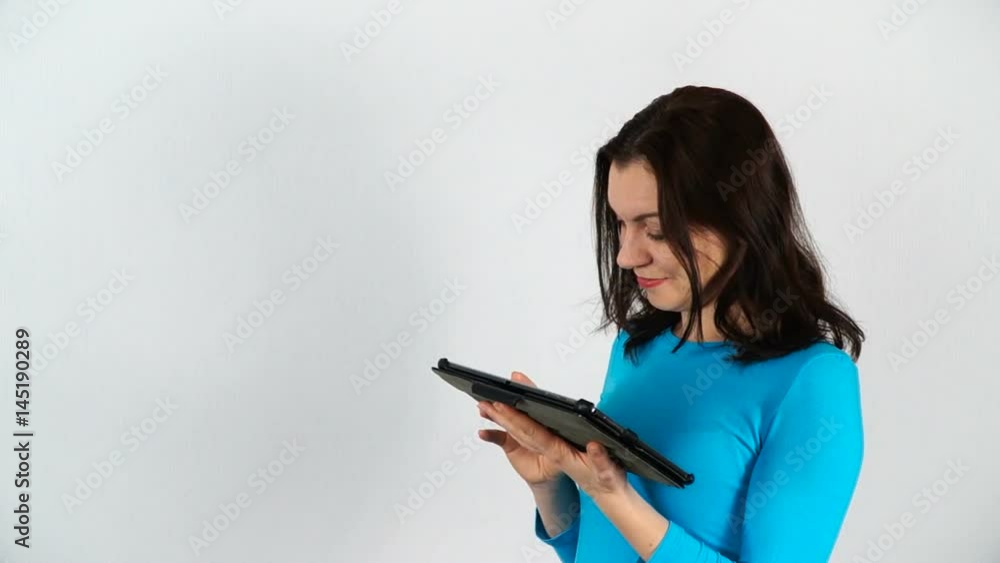 A woman is working with a digital tablet. Model of European appearance on a white background. A woman is working with a digital tablet. Model of European appearance on a white background.