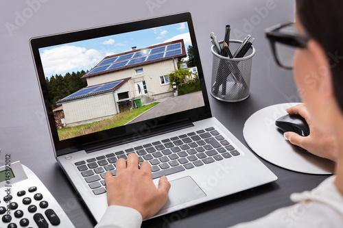 Businesswoman Looking At House On Laptop